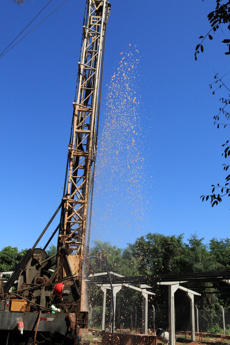 Well drilling rig with water gushing out under pressure