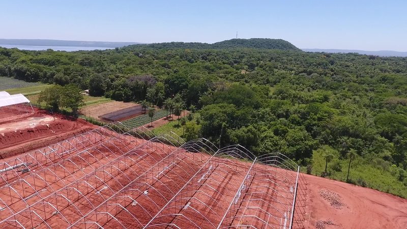 Greenhouse complex seen from a drone, with the hill in the background